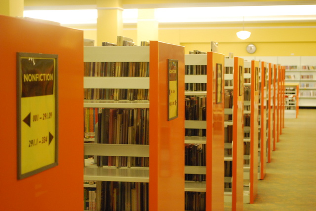 (signs on the shelves at a library, showing the range of Dewey Decimal codes of the books on each shelf)