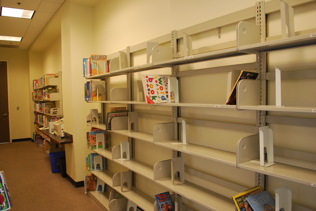 (mostly empty bookshelves in some back room at the library)
